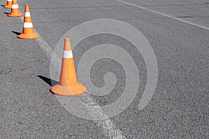 Bright orange traffic cones on asphalt road. Traffic signal cones considered universal products, with their help you can quickly