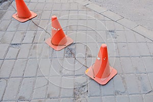 Bright orange traffic cones standing in a row on asphalt