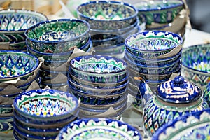 Bright oriental colored plates. Authentic dishes hand-painted in national style. Beautiful bowls and plates in the oriental bazaar