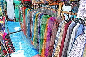 Bright Pants hang on hangers in a row. Showcase with clothes. Clothes India. Bazaar market in India, Anjuna market