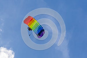 Bright parachutist on the background of blue sky