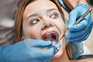 Bright people. Big results. Attractive woman at the dental office. Dentist examining patient`s teeth in clinic.