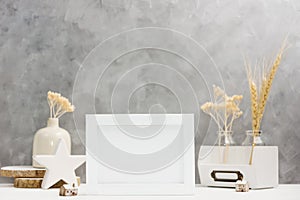 Bright Photo frame mock up with plants in vase, ceramic decor on shelf against grey wall. Scandinavian style