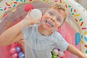 Bright photo of a happy child smiling while playing, looking at the camera.