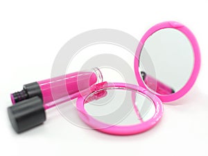 Pink pocket mirror with bright lipstick woman cosmetics on a white background