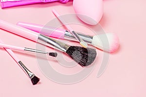 Bright pink decorative cosmetics tools and accessories for professional make up and visage on light background.