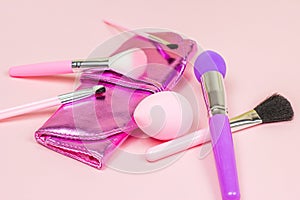 Bright pink decorative cosmetics tools and accessories for professional make up and visage on light background.