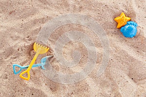 Bright plastic children`s toys in the sand. Concept of beach recreation for children. Children`s summer games. Summer