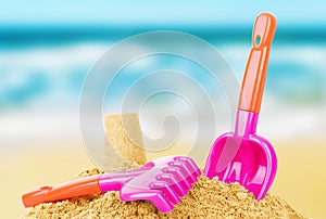 Bright plastic children`s toys in the sand. Concept of beach recreation for children. Children`s summer games. Summer concept