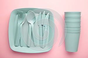 Bright plastic disposable tableware on pink background