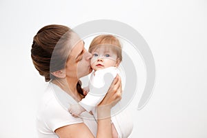 Bright portrait of happy mother holding infant child on hands. Mother hugging her little 6 months old baby. Childhood