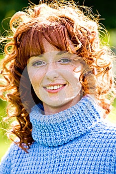 Bright portrait of red-haired young woman outdoors