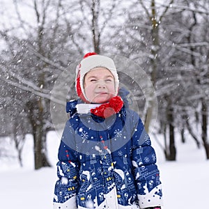 A bright positive photo of a smiling little girl enjoying winter and snow