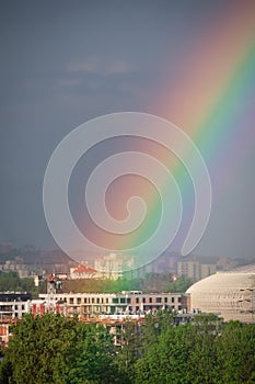 A bright rainbow in the big city. Crane and building construction site