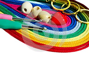 Bright rainbow palette of multi-colored, cotton threads, hooks and accessories isolated on a white background
