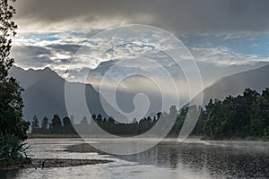 Bright ray of morning sun over the Lake Matheson