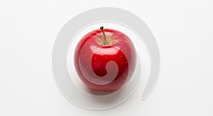 A bright red apple rests against a plain white background. It
