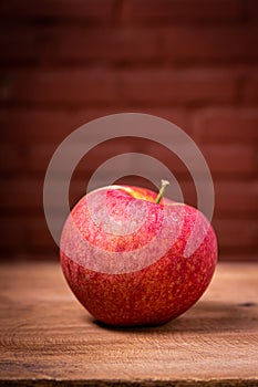 A bright red apple on a wooden table