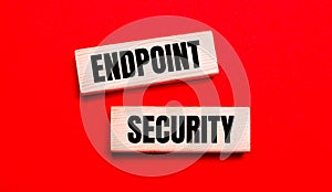 On a bright red background, there are two light wooden blocks with the text ENDPOINT SECURITY