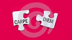 On a bright red background, two white puzzles with the text CARPE DIEM. View from above