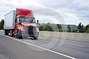 Bright red big rig semi truck with cab spoiler transporting semi photo