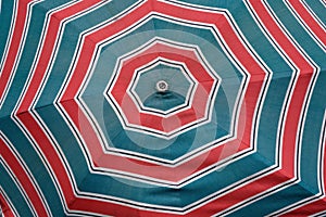 A bright red and blue pattern on a beach umbrella