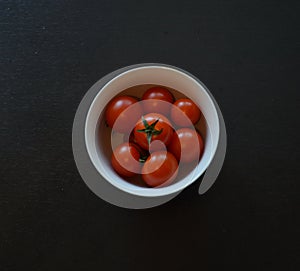 Bright red Cherry Tomatoes, White Bowl, White Lacy Napkin, Black Table