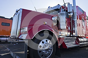 Bright red classic fancy big rig semi truck tractor with chrome