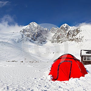 Bright red climbing tent on snow