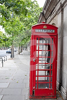 A bright red coloured telephone booth in central London, Uk