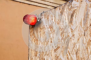 Bright red construction lamp lit with fence in background on entrance of construction site at night