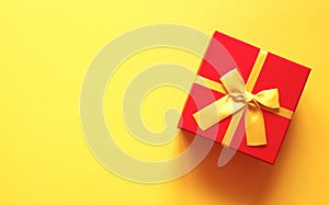 Bright red gift box on yellow background