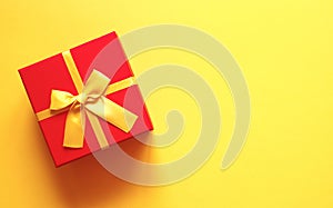 Bright red gift box on yellow background
