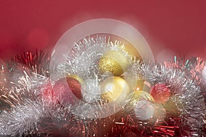 Bright red and gold balls on blurred sparkling background, bokeh lights. Golden new year 2021. Merry Christmas card