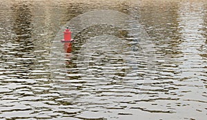 Bright red metal buoy float mark for ships on the smooth spring