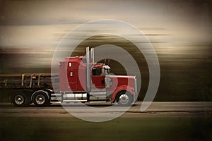 Bright red big rig semi truck and trailer in motion on a highway