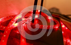 Bright red New Years and Christmas rice lights. Abstract red light background. Decorative flashing lights, ornaments to christmas.