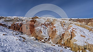 Bright red-orange hillsides against a clear blue sky. photo