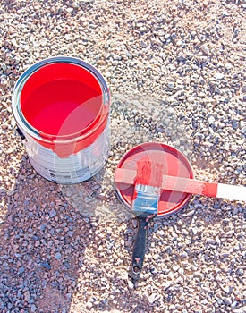Bright red paint in can and brush