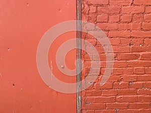 Bright red painted barn building slip between wood siding and old brick wall