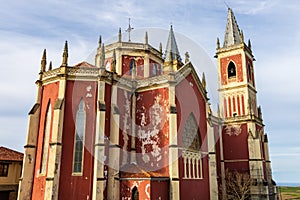 Bright red Parish Church of San Pedro Ad Venceya. Cóbreces, Cantabria, Spain