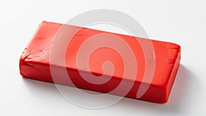 Bright red rectangular block of material on a white surface