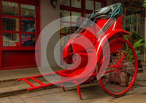 A bright red rickshaw in a back alley in a Beijing hutong - 1