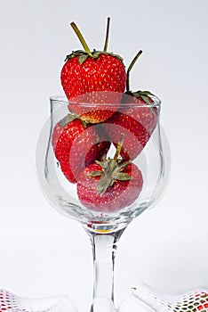 Bright red ripe strawberries in a clear glass