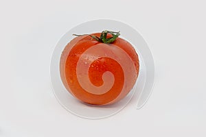 Bright red round tomato with water drops