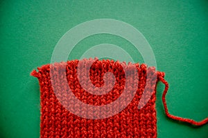 Bright red scarf with knitting needles