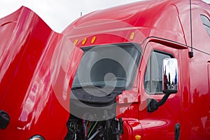 Bright red semi truck cab with open hood