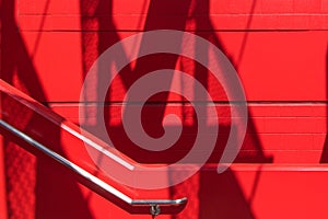 Bright red staircase wall, concrete block wall and stainless steel hand rail in a modern structure