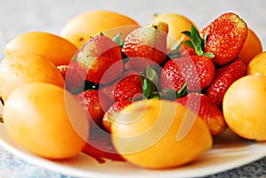 Bright red strawberries with mango plums