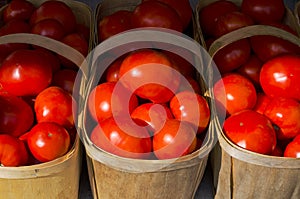 Bright red tomatoes in farmers wooden baskets at market